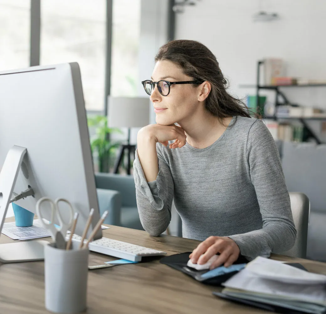 Professional woman sitting at desk and connecting with her computer, she is working from home