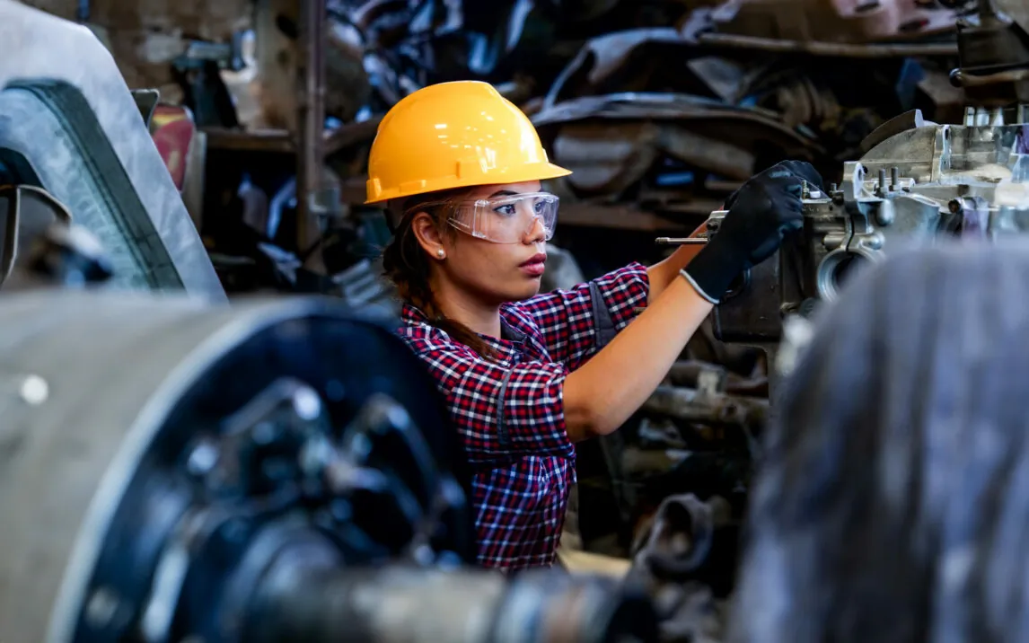 Young Engineer woman working with machine in factory.