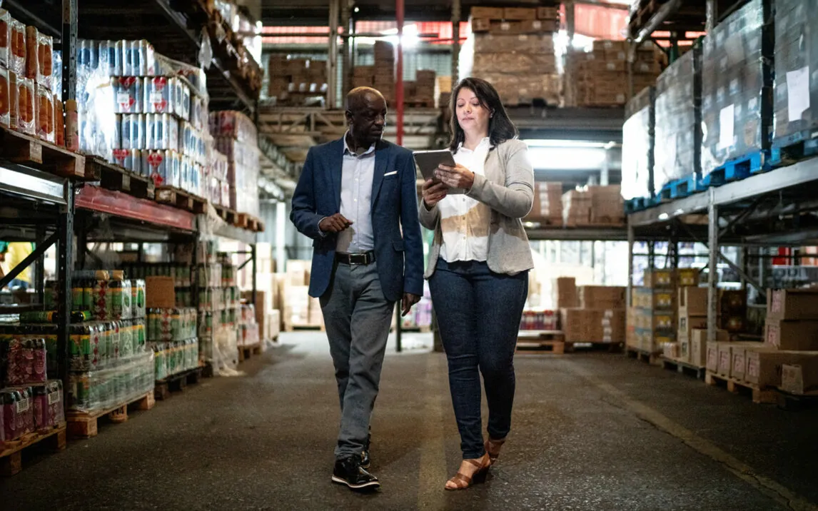 Coworkers talking while walking in a warehouse