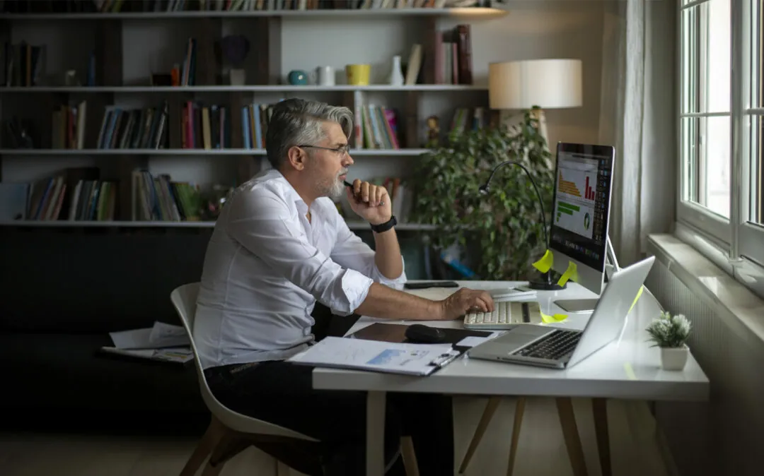 Homem de negócios, em regime de teletrabalho, a analisar gráfico no computador