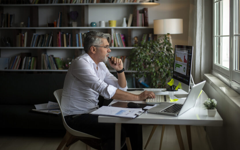 Homem de negócios, em regime de teletrabalho, a analisar gráfico no computador