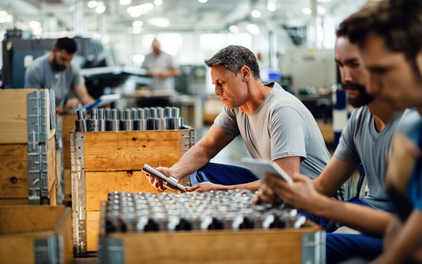 Trabalhador a analisar varões de aço antes da distribuição, numa fábrica de metais.