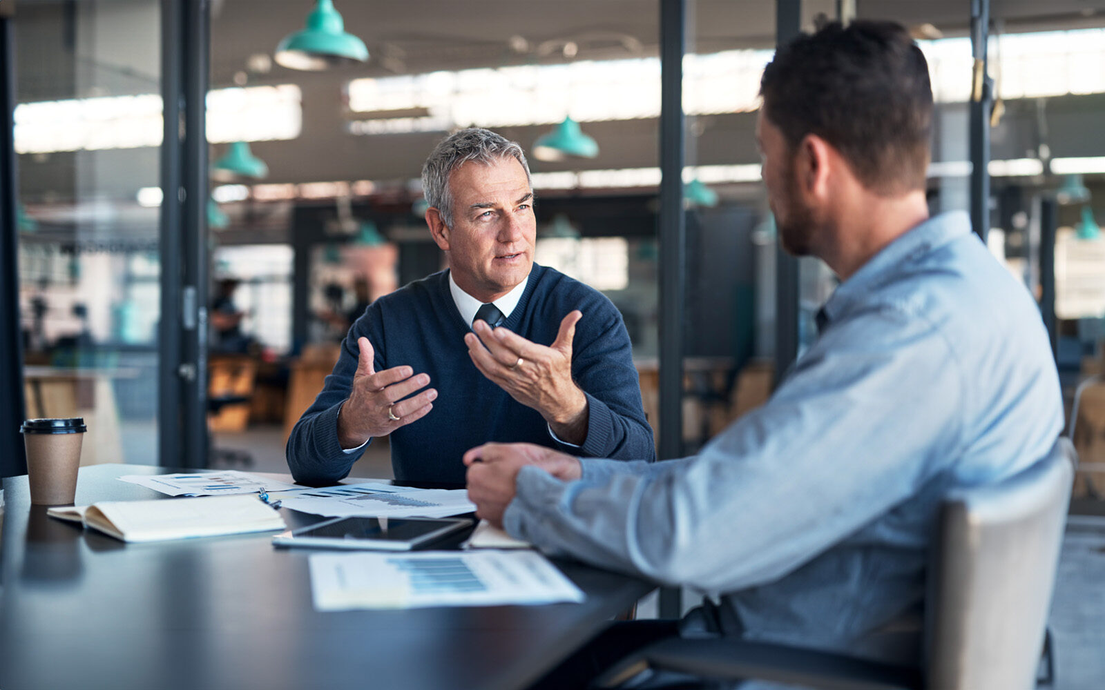 Shot of a mature businessman having a discussion with a colleague in an office