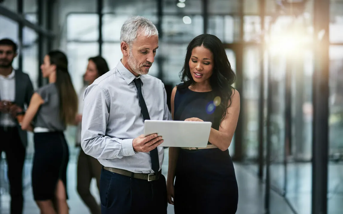 Shot of two professional coworkers using a digital tablet together at work