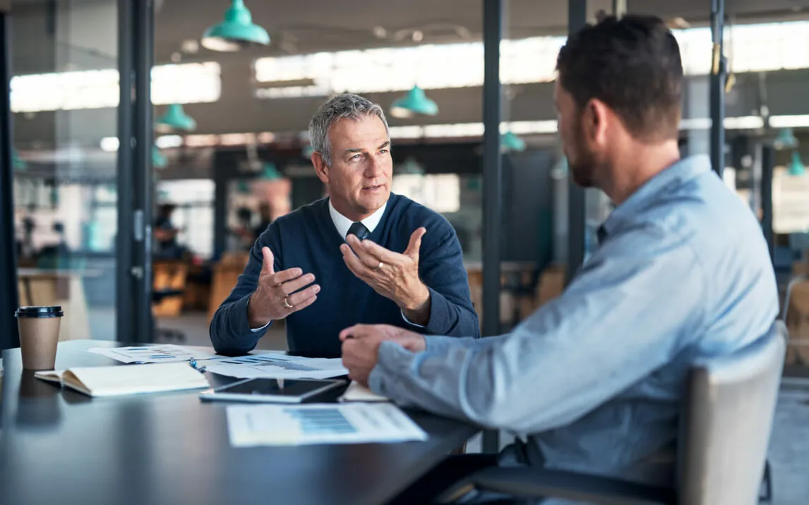 Shot of a mature businessman having a discussion with a colleague in an office