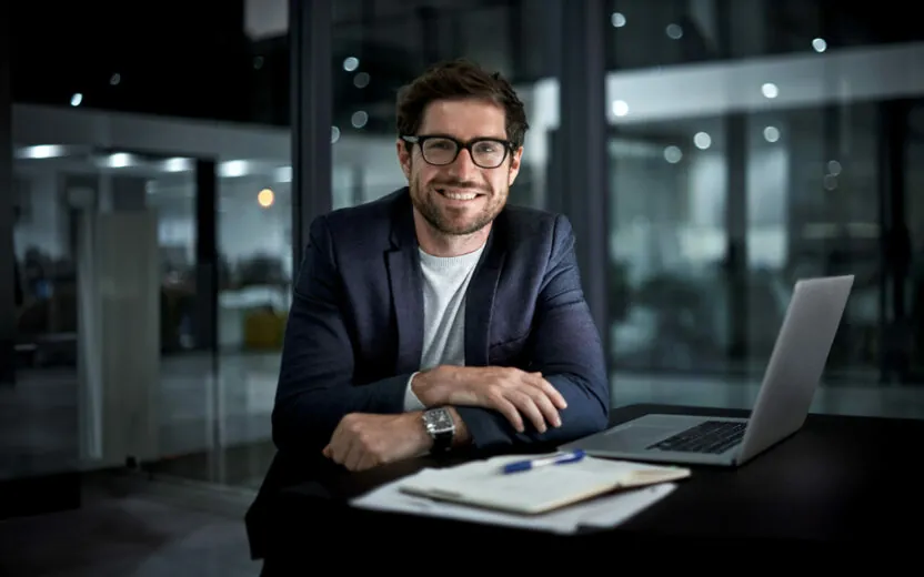 portrait of a happy young businessman working at his office desk