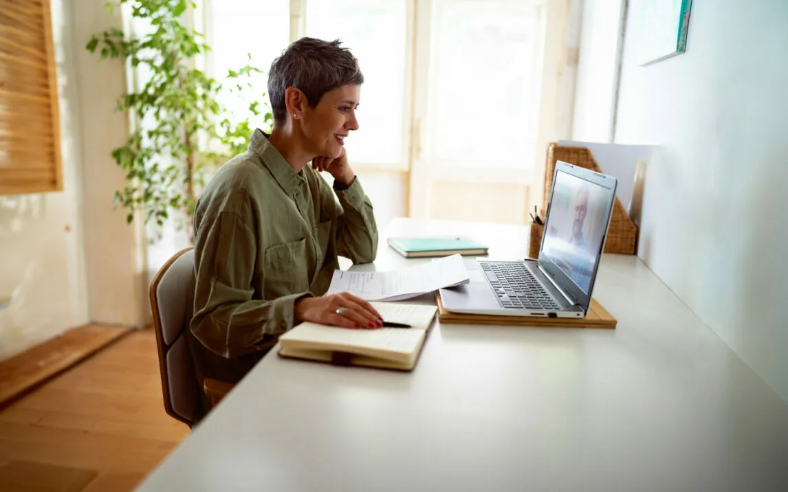 Woman following online courses on her laptop at home.