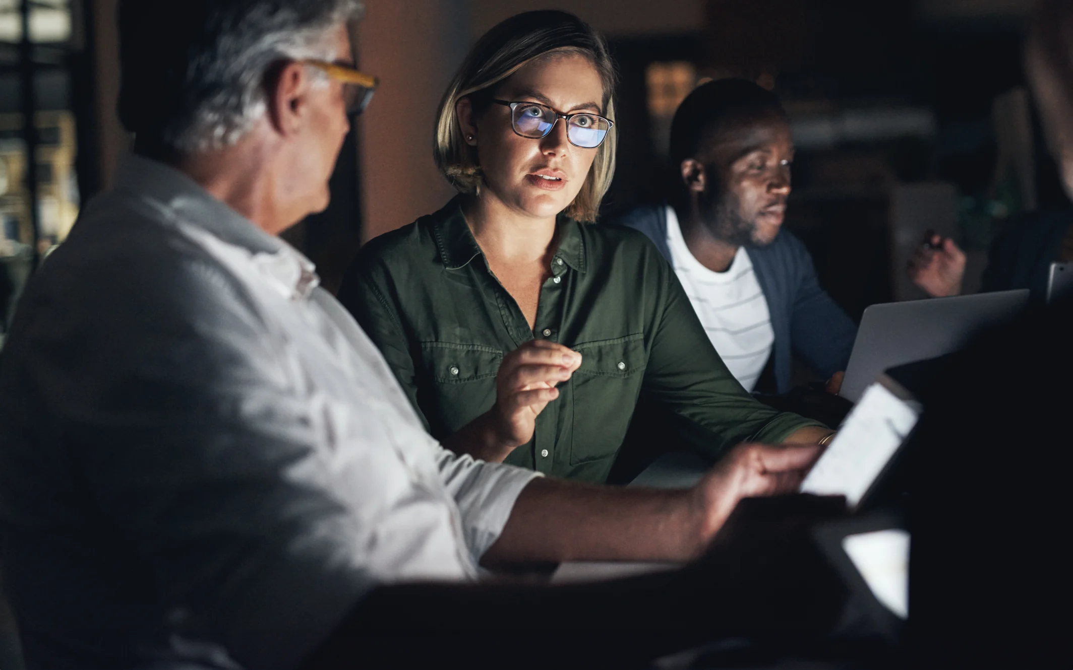 Uma reunião onde está um homem com um tablet na mão e uma mulher a falar