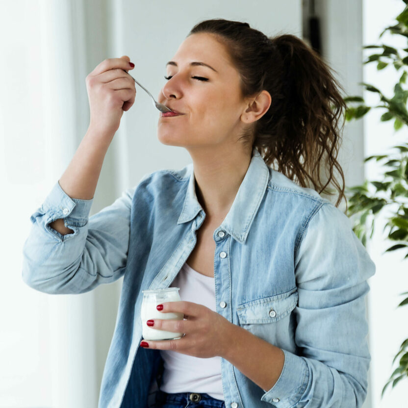 Woman eats yoghurt - Emmi Success Story - MicroStrategy