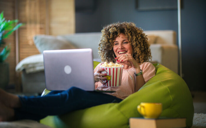Woman watching online tv and lying on a lazy bag in the living room