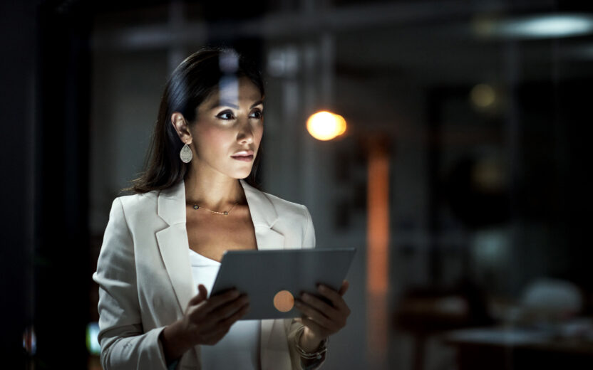 Aufnahme einer jungen Geschäftsfrau, die bei der Arbeit ein digitales Tablet benutzt