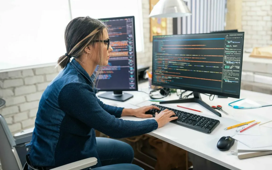 Weibliche Entwickler Kodierung und Programmierung. Coding auf zwei mit Bildschirmen mit Code-Sprache und Anwendung.