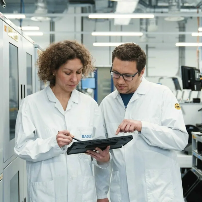 Basler AG employees looking at tablet