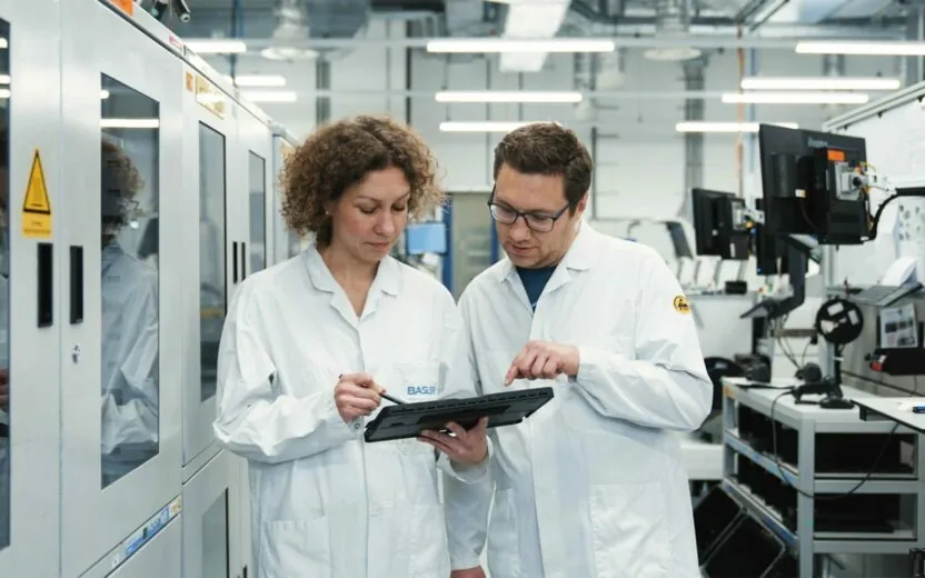 Basler AG employees looking at tablet