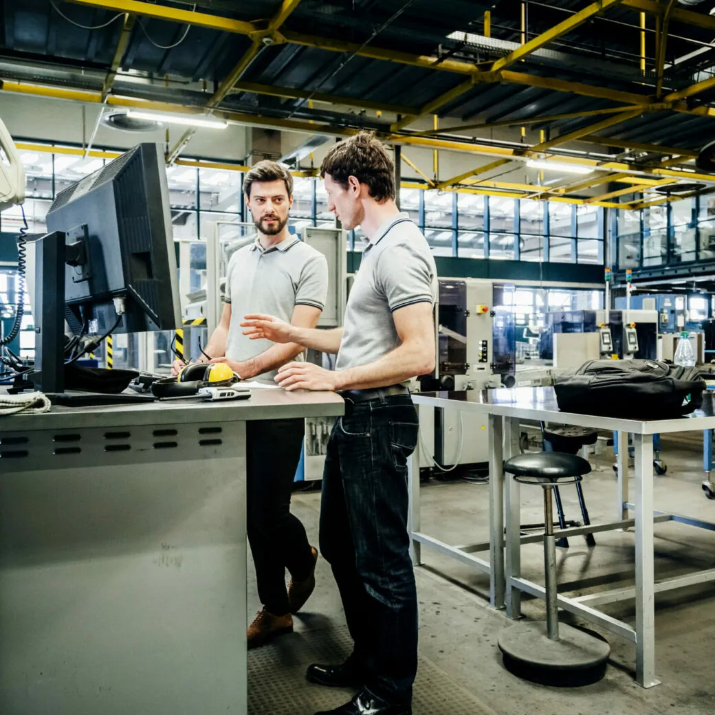 Two engineers working at console together