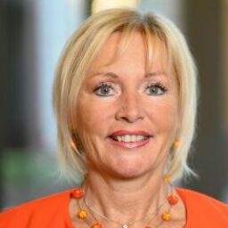 Kristina Sinemus, Minister for Digitalisation and Innovation of the State of Hesse, smiling in a bright orange outfit.