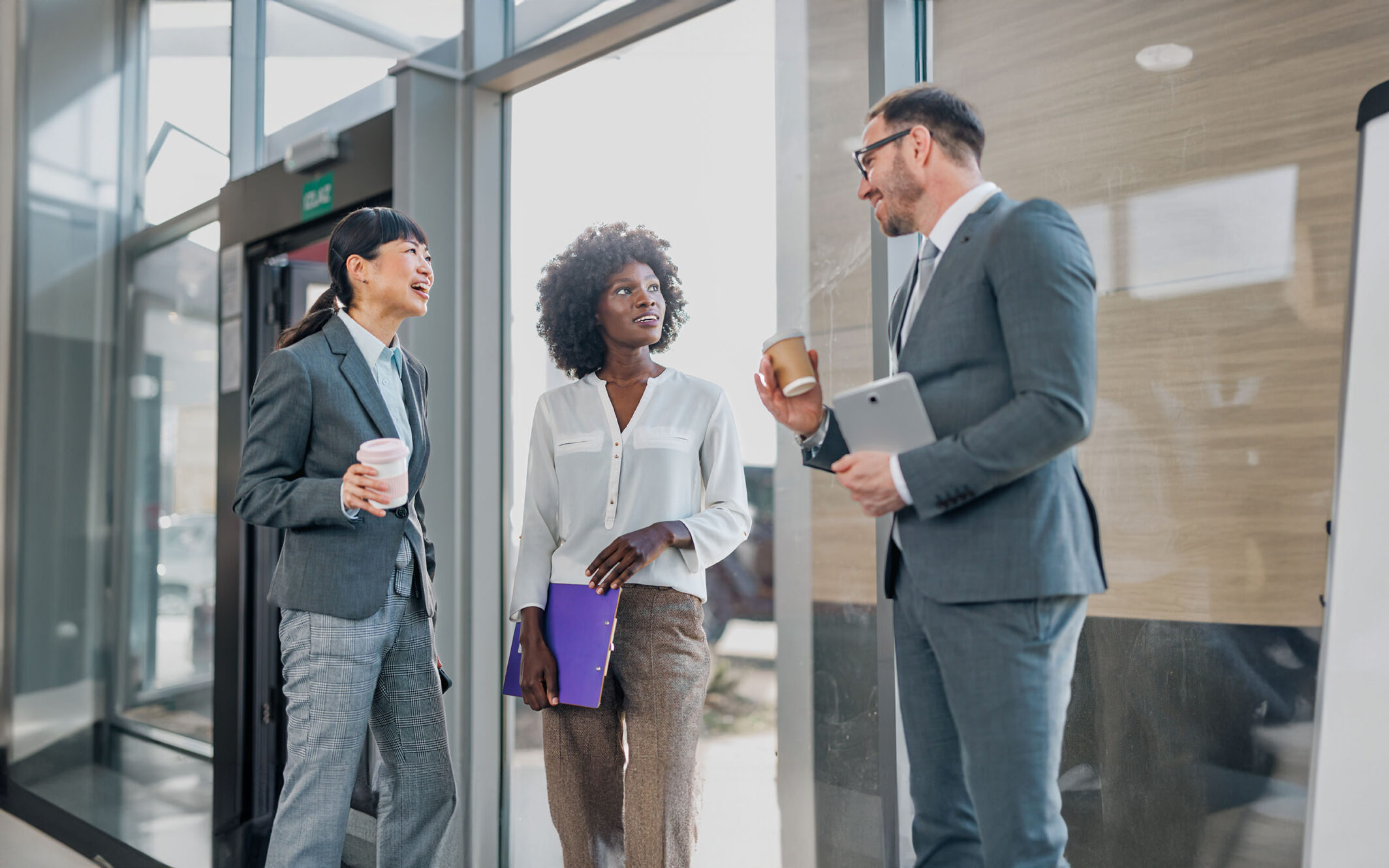 A cohesive team of employees works together harmoniously in an office corridor