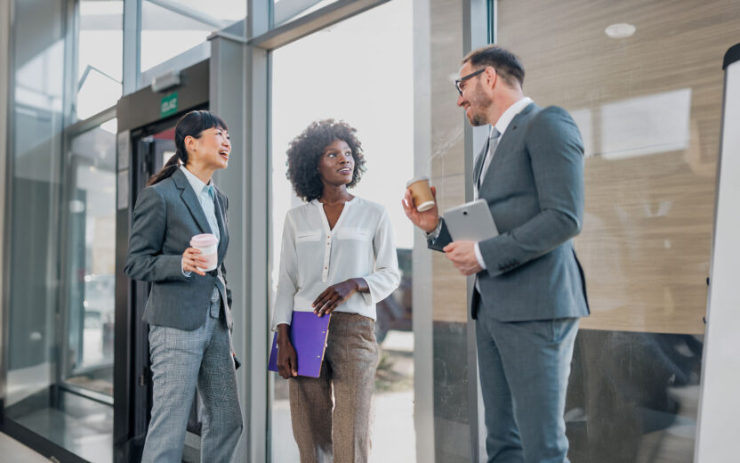 A cohesive team of employees works together harmoniously in an office corridor