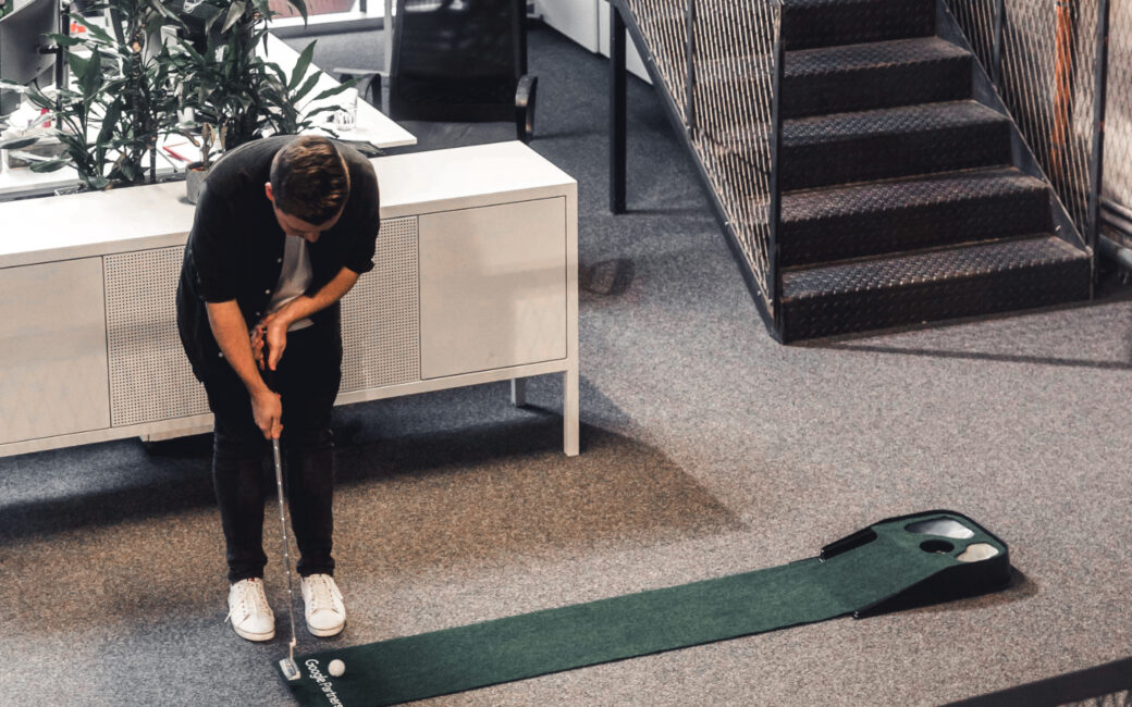 Mitarbeiter von valantic Austria spielt im Office Mini-Golf