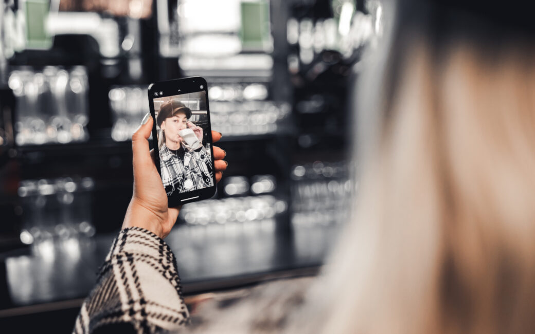 Influencerin, die ein Selfie beim Kaffeetrinken macht.