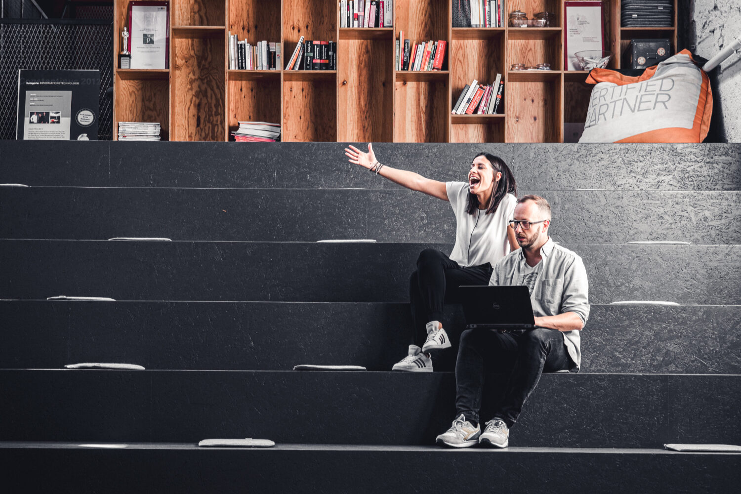 Zwei valantic Austria Mitarbeiter*innen, die auf einer Treppe sitzen.