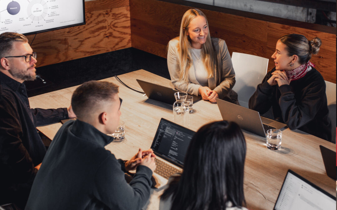 Eine Gruppe valantic-Austria Mitarbeiter*innen sitzen zusammen in einem Meeting