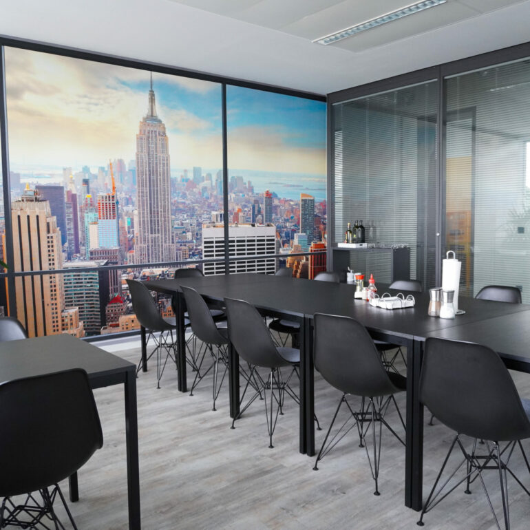 Schöner, gemütlicher Lunchroom mit schwarzen Möbeln, Holzboden und einem Foto von New York an der Wand