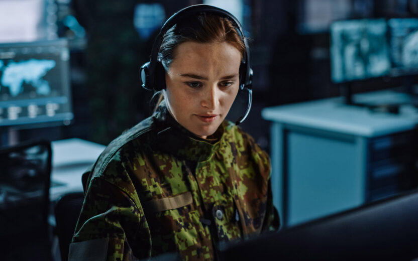 female military surveillance officer in headset working in central office