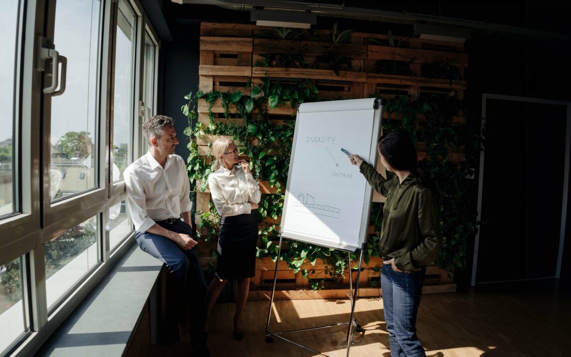 Business people working with flip chart in green office