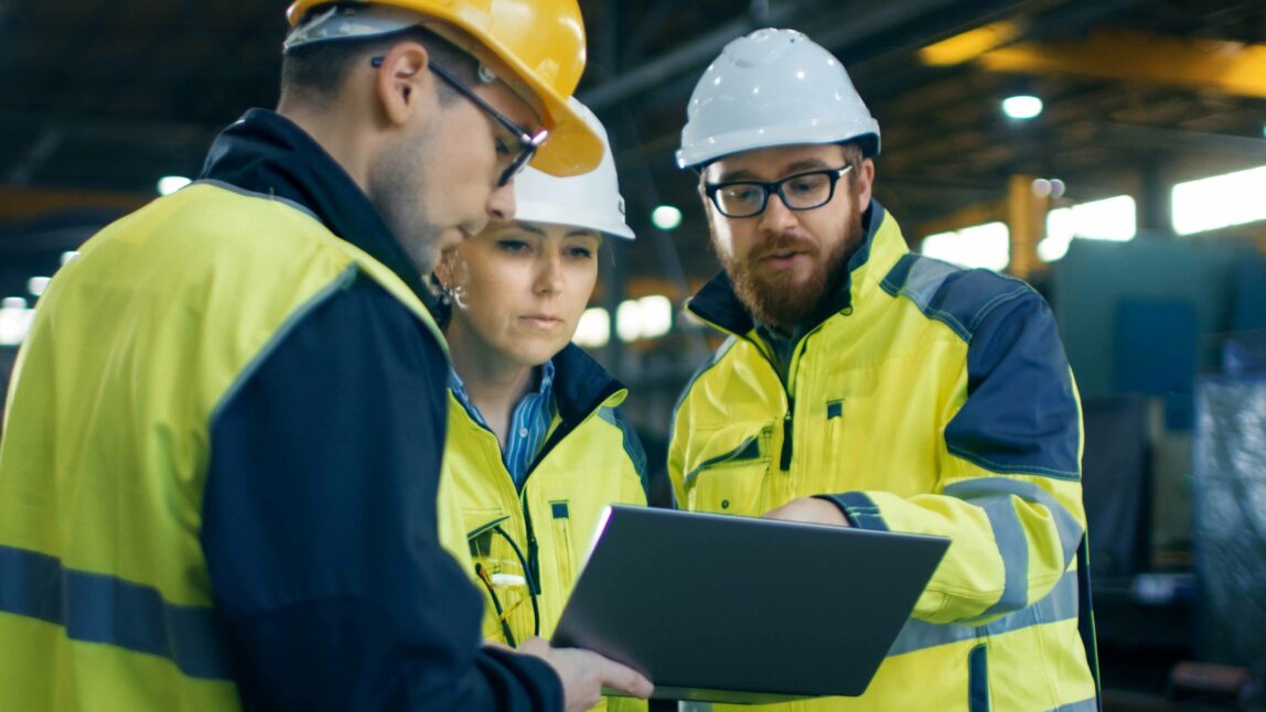 group of 3 people chatting and working in factory building with sap s/4hana asset management