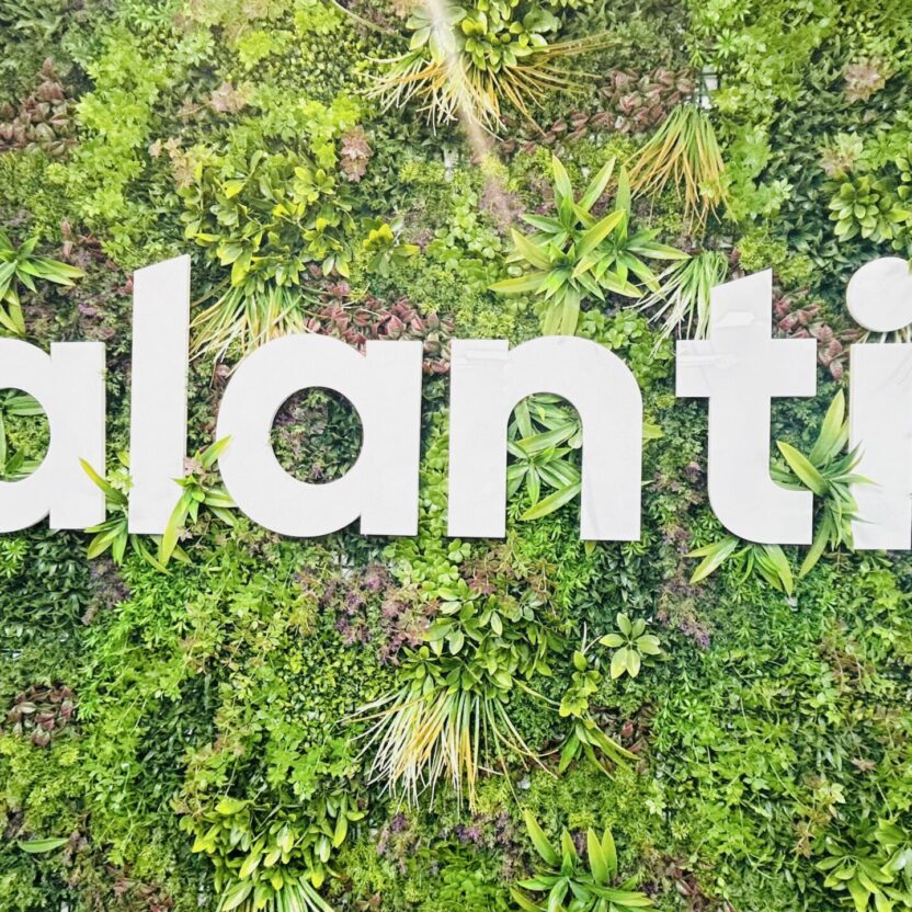 The word "valantic" is elegantly displayed in white letters against a vibrant green living wall, featuring an array of lush plants reminiscent of Indore's rich greenery.