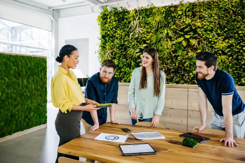 Office Team having Meeting At Large Desk In Their Office