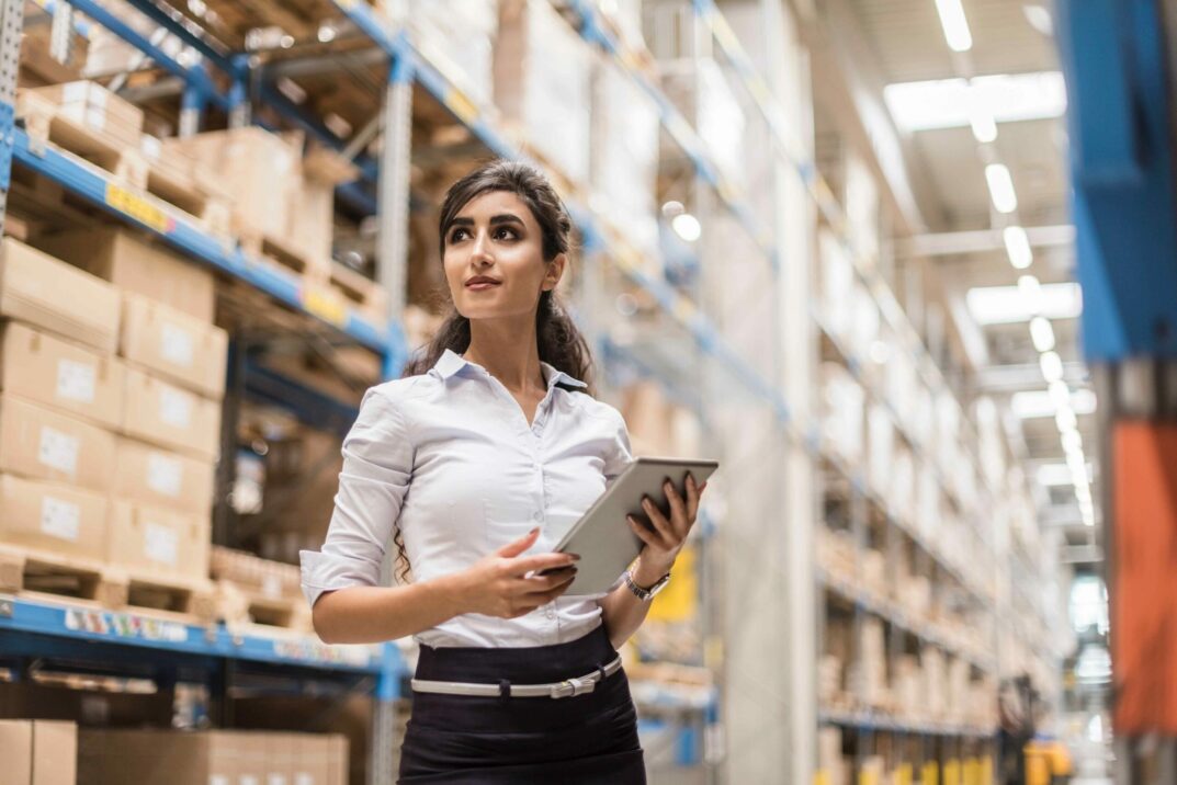 woman standing in warehouse with IPad