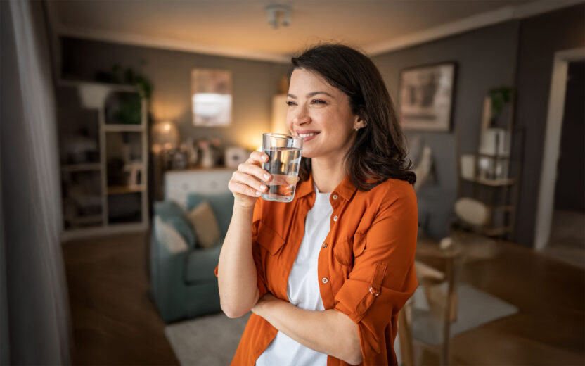Smiling woman holding a glass of fresh water