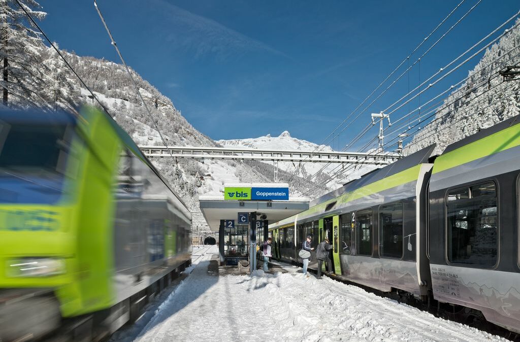 bls Zug fährt ein in Schweizer Bahnhof, Menschen steigen ein