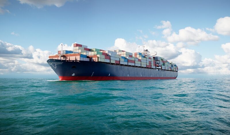 3d cargo container ship in ocean, large cargo vessel loaded with containers sailing in sea