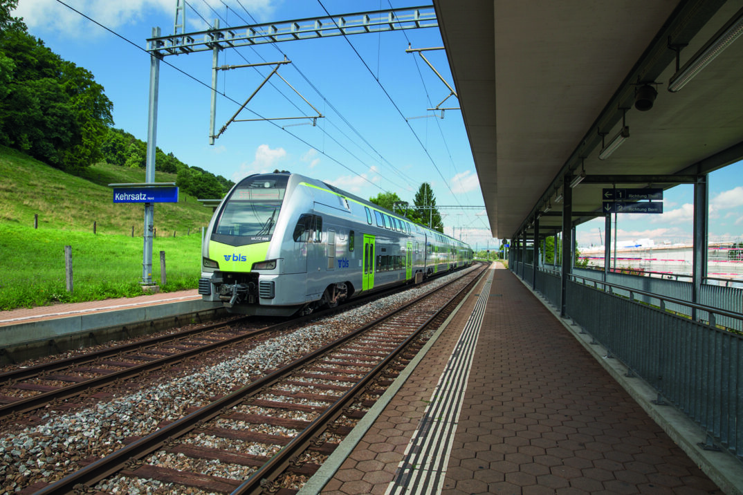 Green BLS train pulls in, platform in view