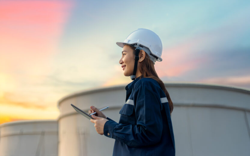 Petroleum oil refinery engineer worker in oil and gas industrial with personal safety equipment PPE to inspection follow checklist by tablet. Classic Energy business concept.