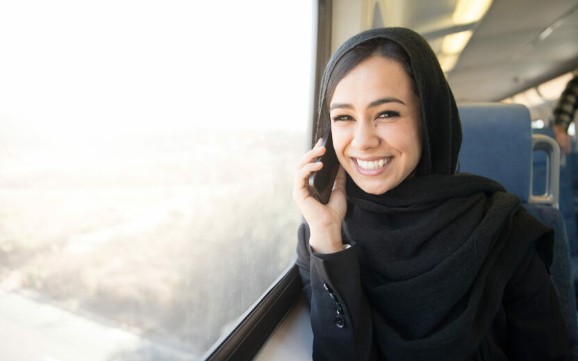 Young Muslim or Arabic Business Women on the train on her phone.