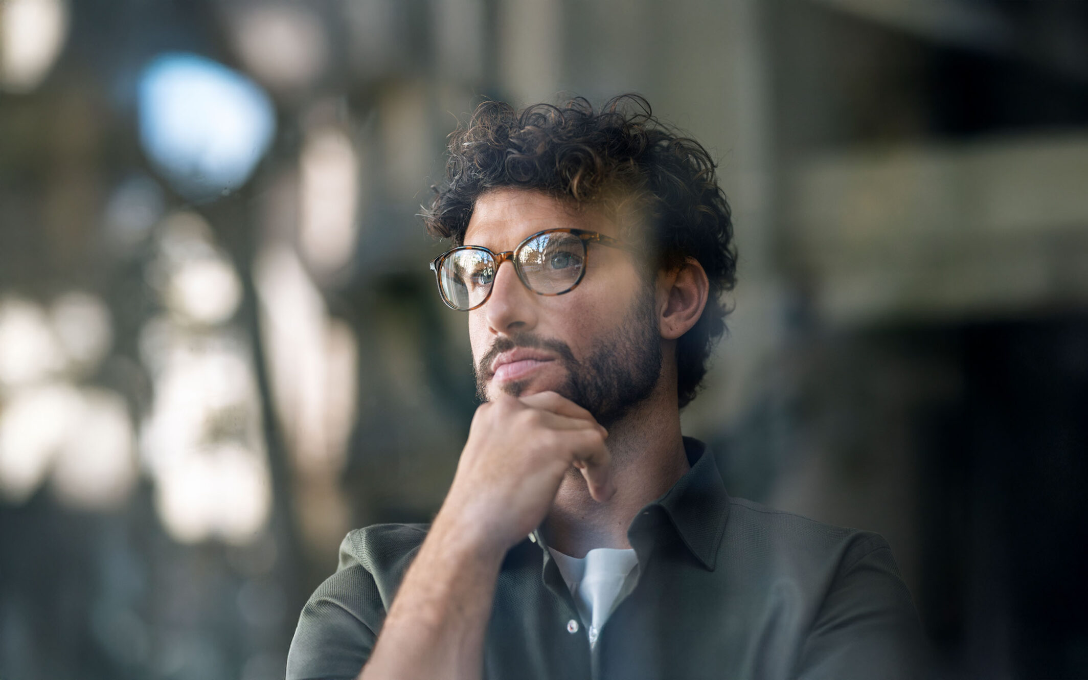 Thoughtful businessman wearing eyeglasses with hand on chin