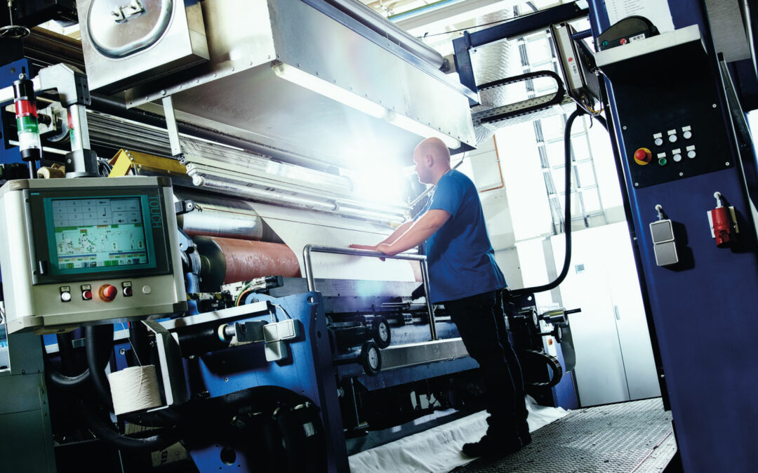 Mann arbeitet an Maschine in der Industrie