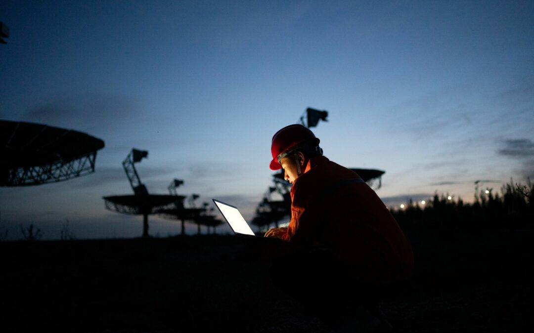 Engineer in hard hat working with laptop