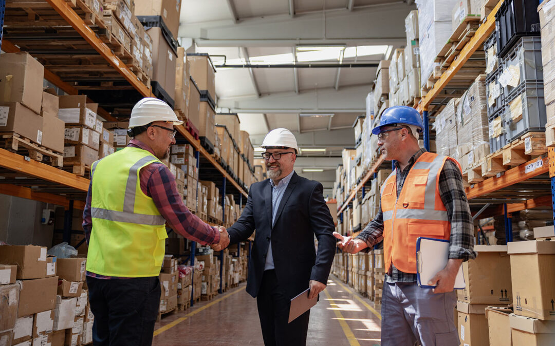 Efficient Collaboration in an Industrial Factory Warehouse: Businessman Engaging with Worker and Engineer, Exchanging Handshake