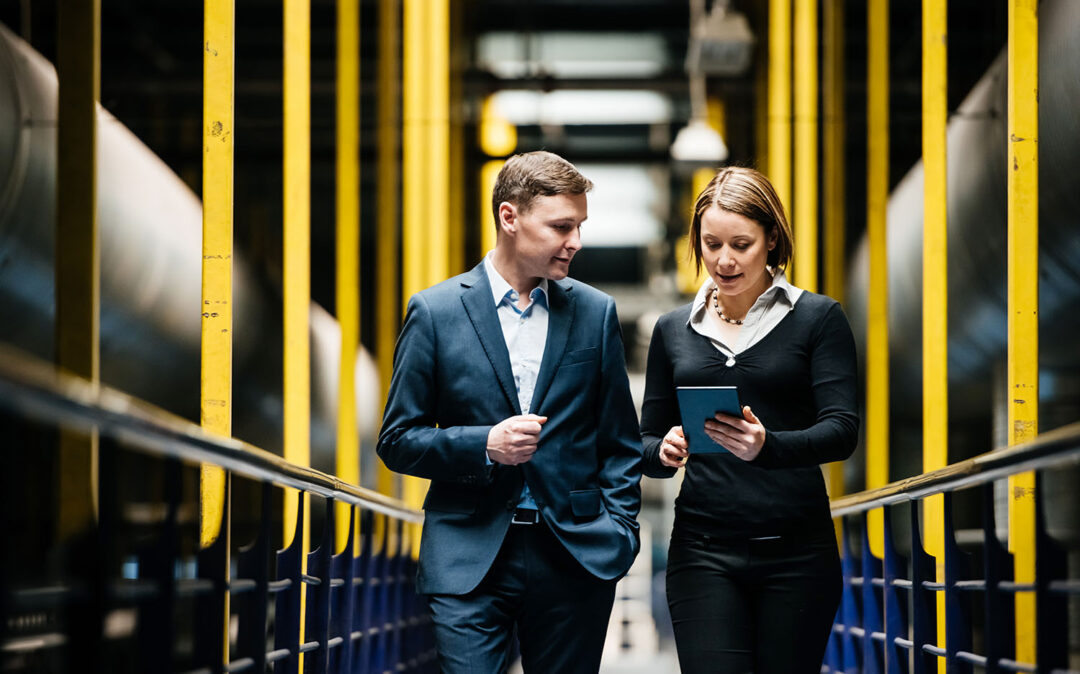 Two business people walking down a dark factory corridor