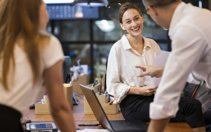 Tech Lead responsibilities in order to build strong development Teams. Smiling Female Software Developer leading a project meeting in tech business office.