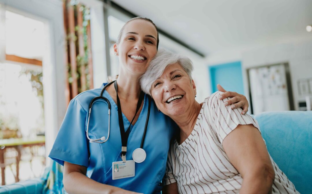 Caregiver holds an elderly, laughing woman in her arms