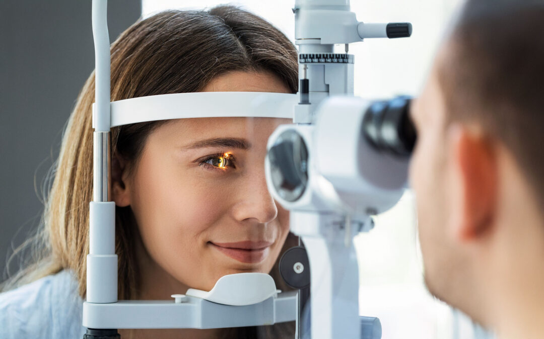 Eine Frau unterzieht sich einer Augenuntersuchung mit einer Spaltlampe, während eine Augenärztin ihr Auge beobachtet.