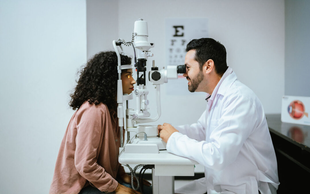 Ein Augenarzt untersucht die Augen eines Patienten mit einer Spaltlampe in einer Klinik.