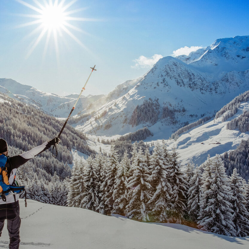 Panoramic image of the Alpbachtal tourism region with a skier in the foreground