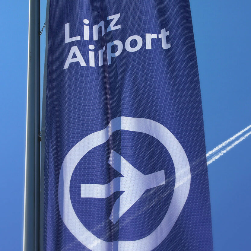 Image of a flag with the Airport Linz logo on it